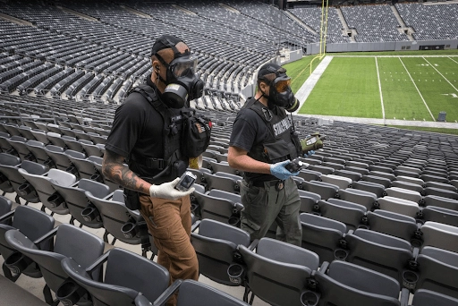 Responders walking through football stadium holding threat detection equipment during a hazardous response training
