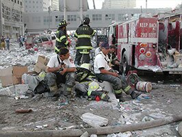 Firefighters sitting on rubble during 9/11 cleanup