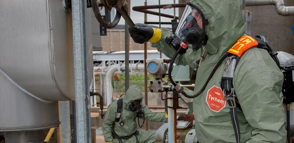 First Responder HazMat operator wearing chemical protective DuPont Tychem 2000 FR coveralls while working on a gas tank