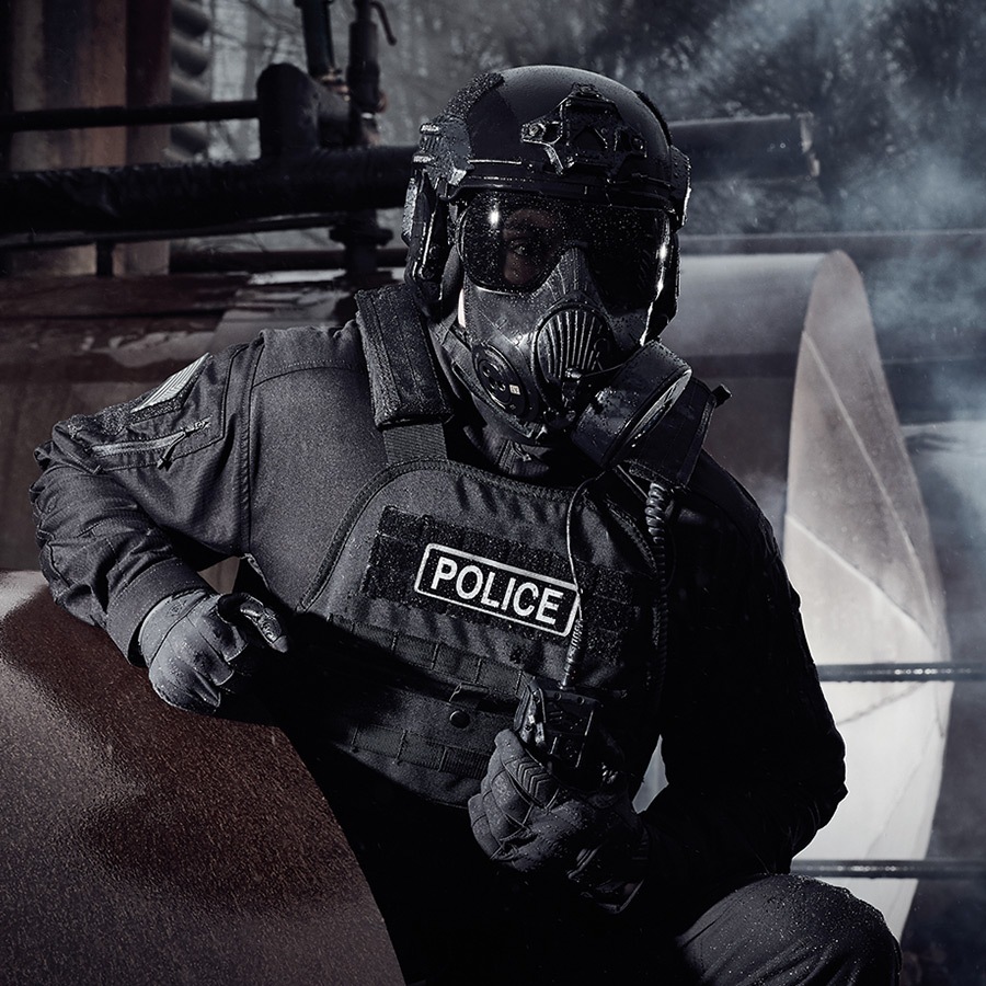 Police Officer wearing protective equipment such as a gas mask and bullet proof vest.