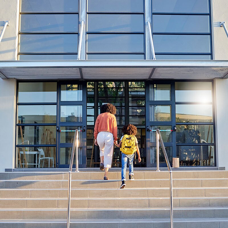 Mother and Child walking into school entrance with windows covered in security anti agressor window film
