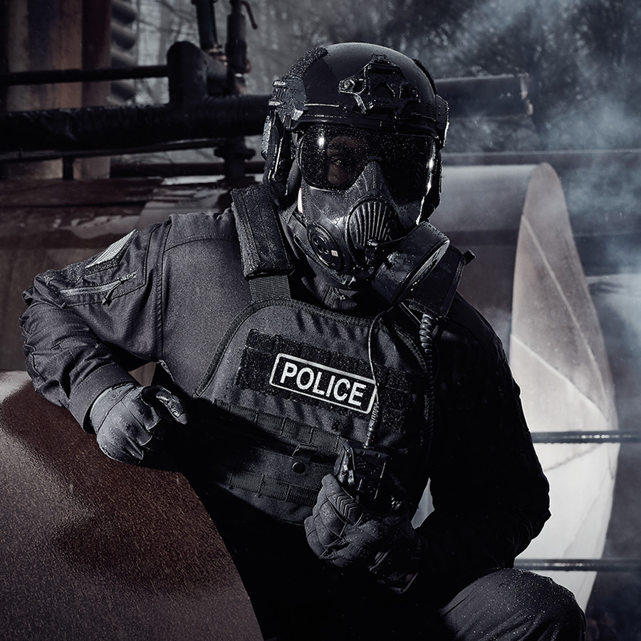 Police Officer wearing protective equipment such as a gas mask and bullet proof vest.