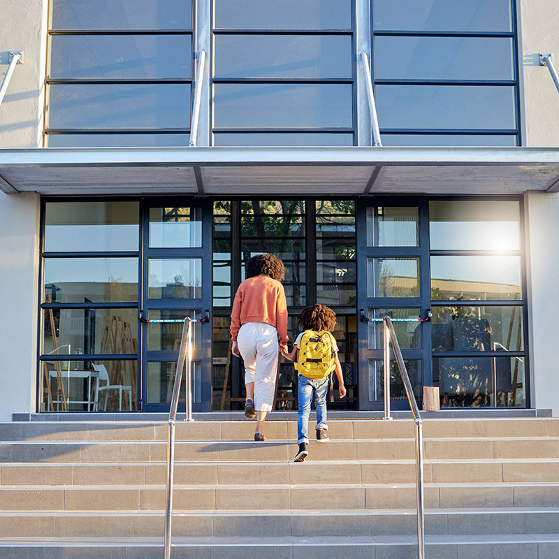 Mother and Child walking into school entrance with windows covered in security anti agressor window film
