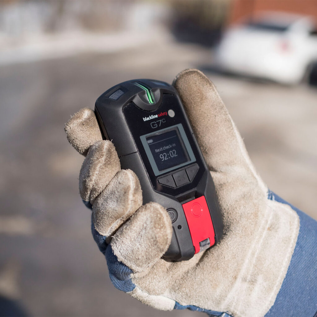 G7 Lone Worker Detector clasped in a gloved hand