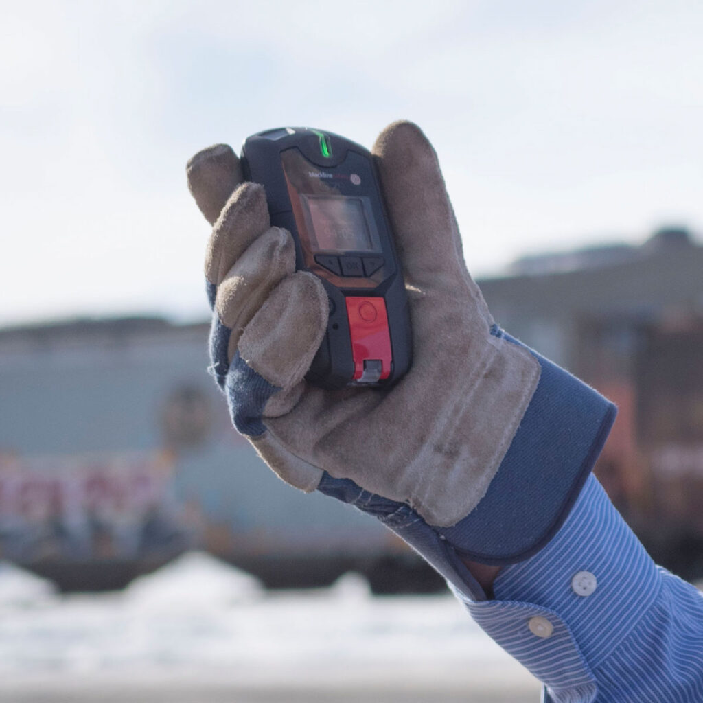 Industrial Worker holding a G7 Lone Worker Detector