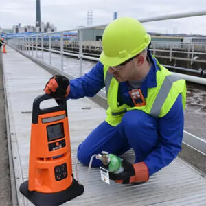 Industrial Scientific Radius BZ1 Area Monitor on sidewalk set up by worker